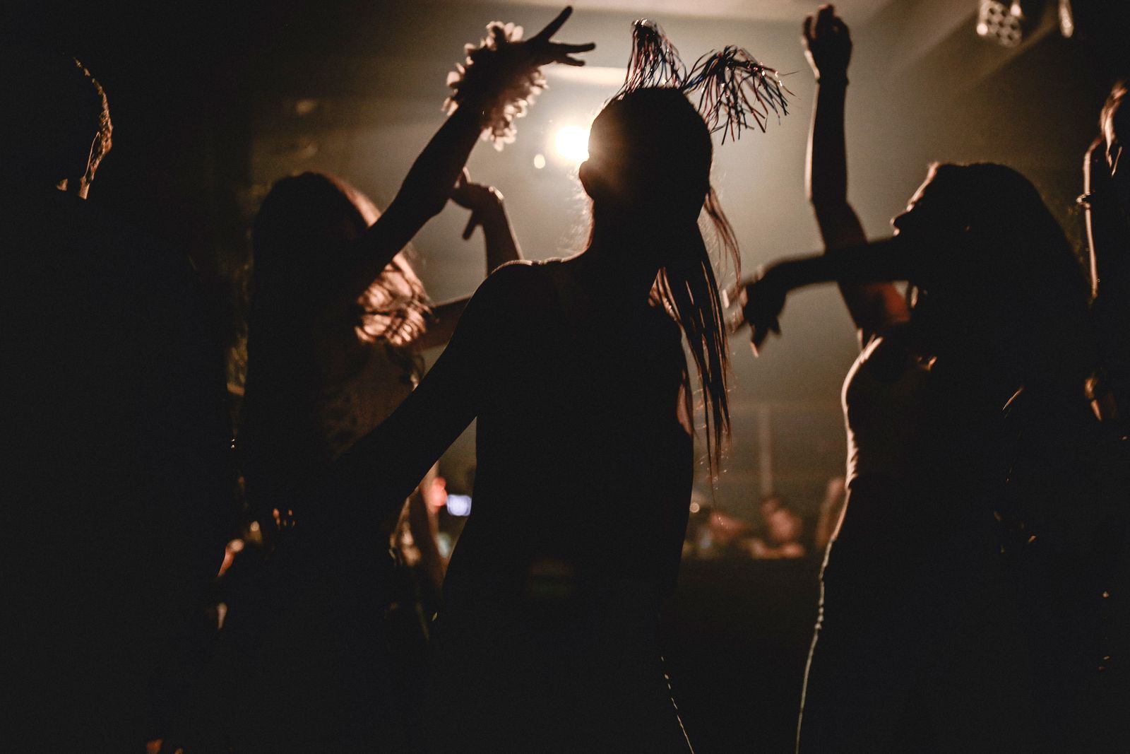 Silhouettes of adults dancing under club lights, the late-night side of fun cruises for adults