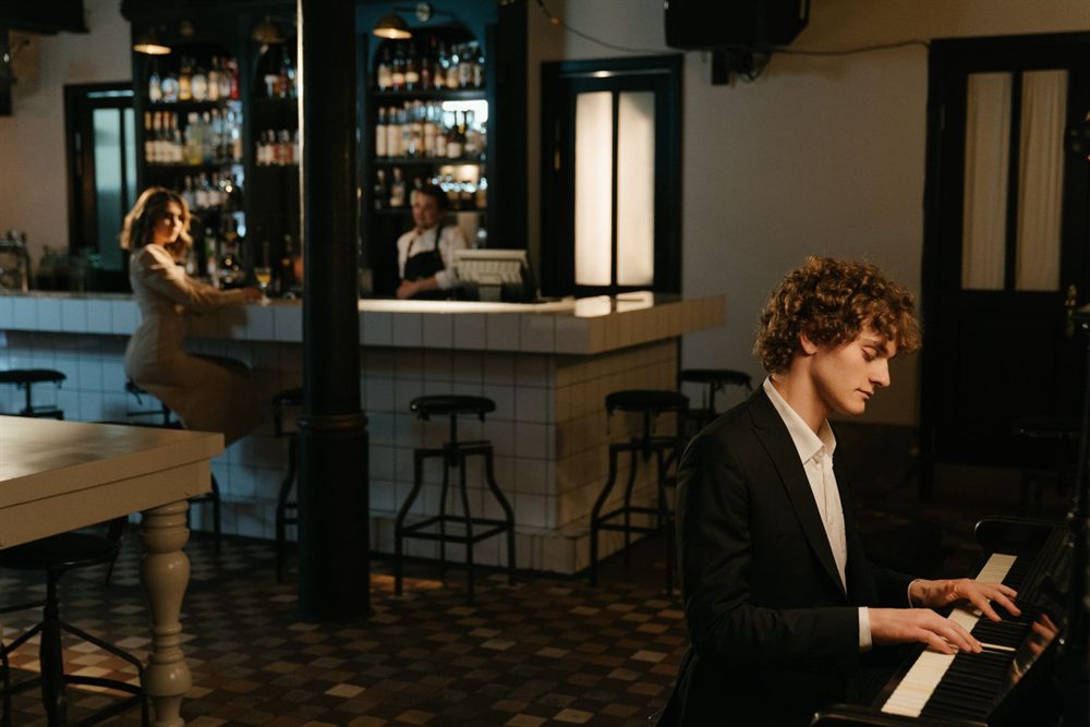 Pianist in a dark suit playing in an elegant bar