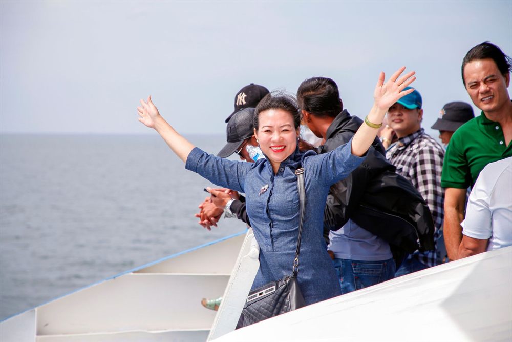 Happy group cheering on the deck of a boat on a sunny day