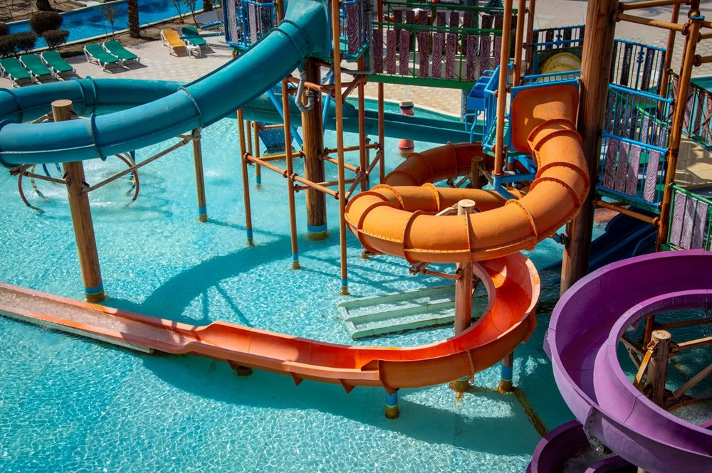 Twisting orange, blue and purple water slides over a pool