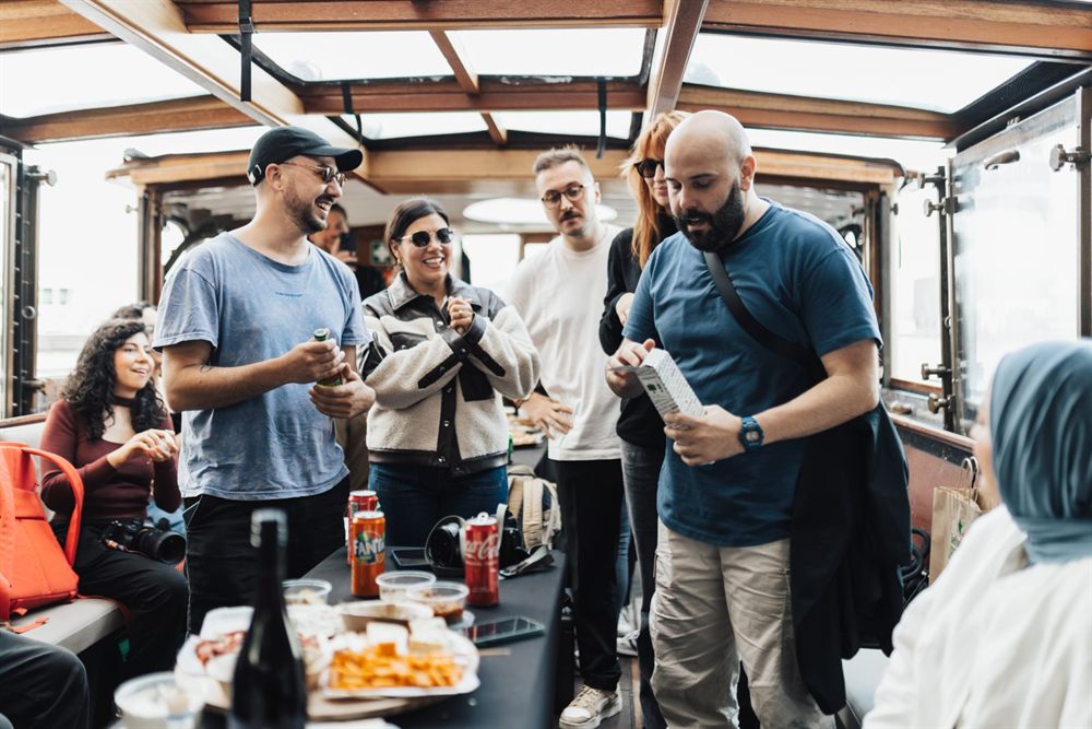 Group of friends laughing over snacks and drinks on a boat