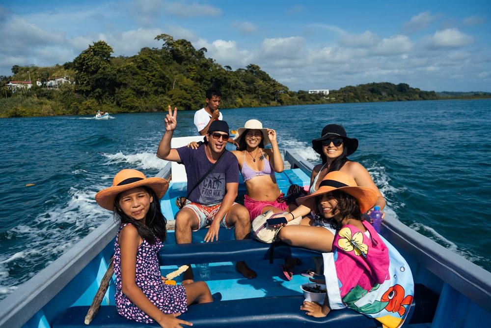 Family in sun hats enjoying a speedboat ride on blue water